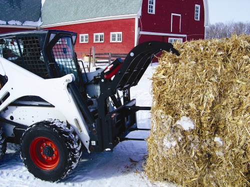 Grapple and Balespear holding a round bale.